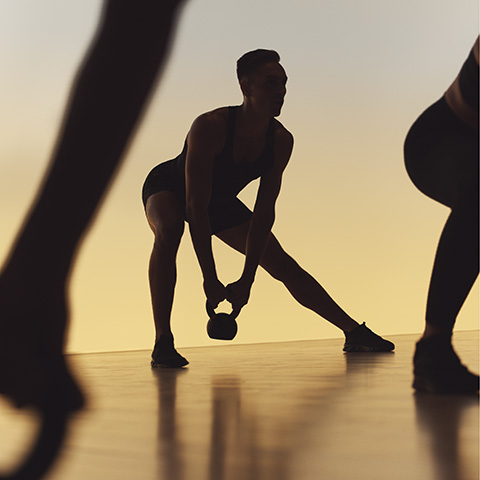 A Life Time member doing a side lunge with a kettlebell