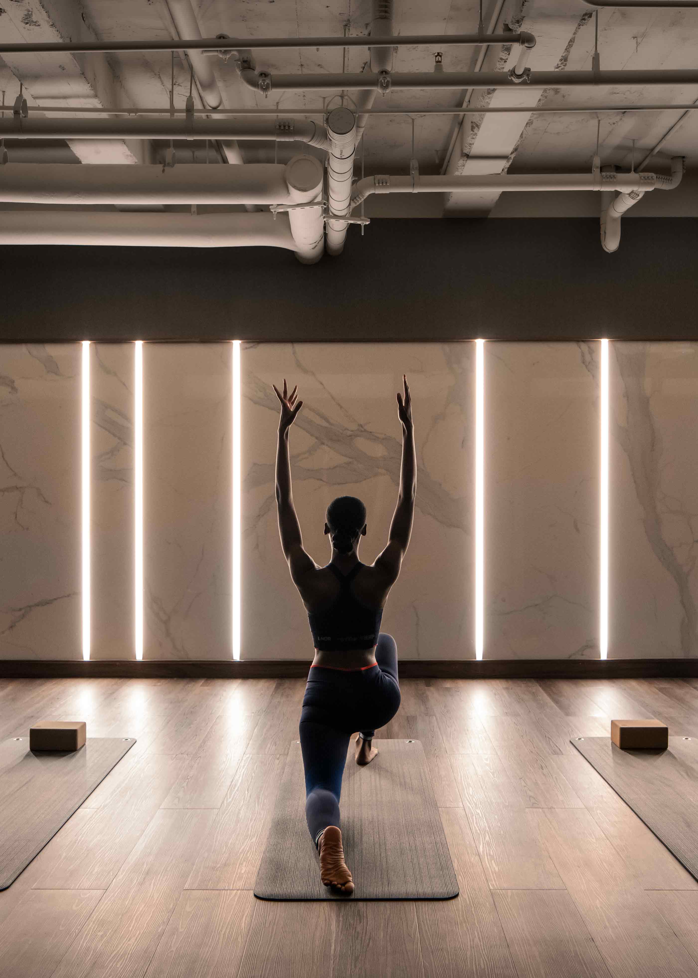 a woman practices a yoga move in a dimly lit room