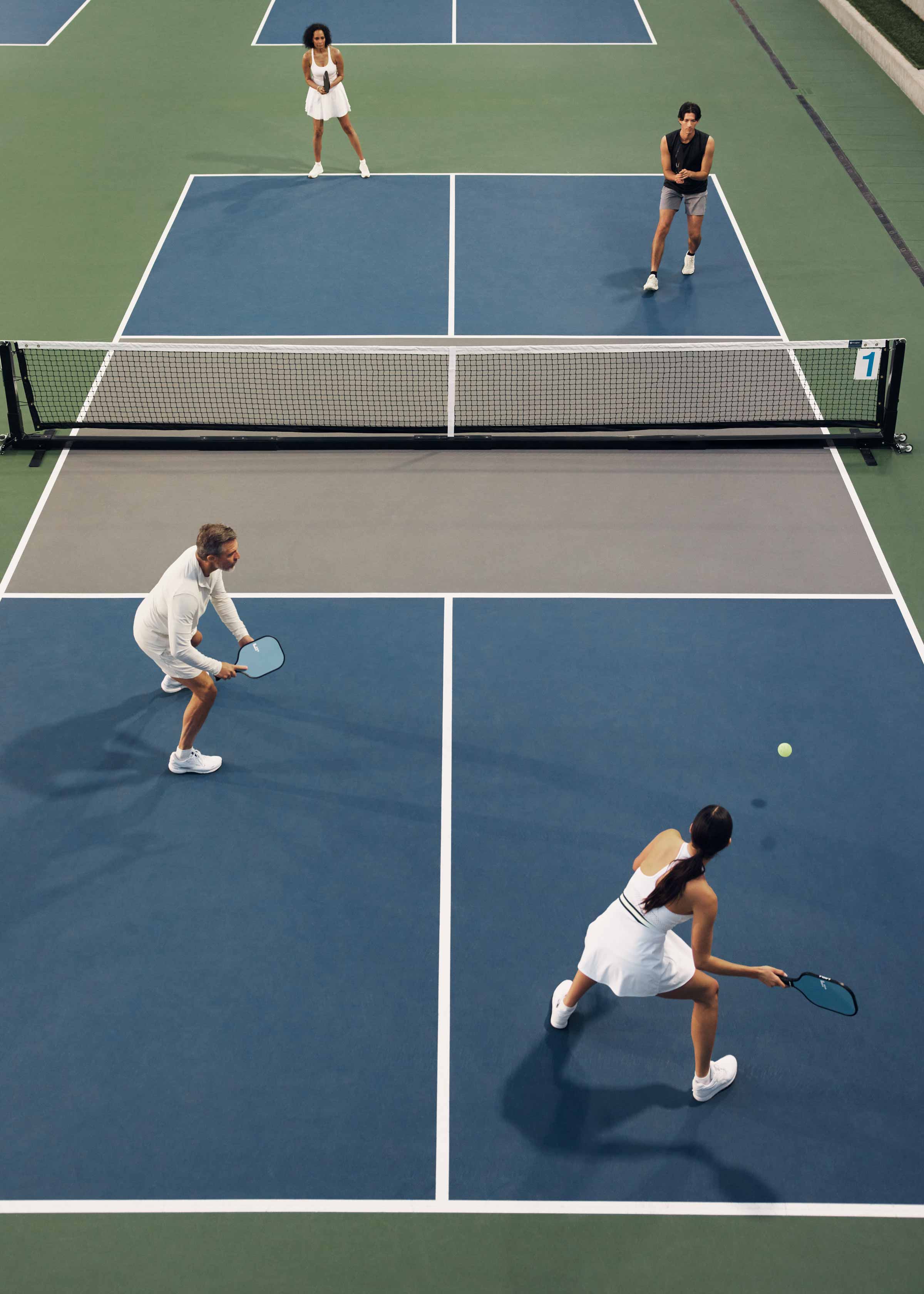 A doubles pickleball match in action on a Life Time court