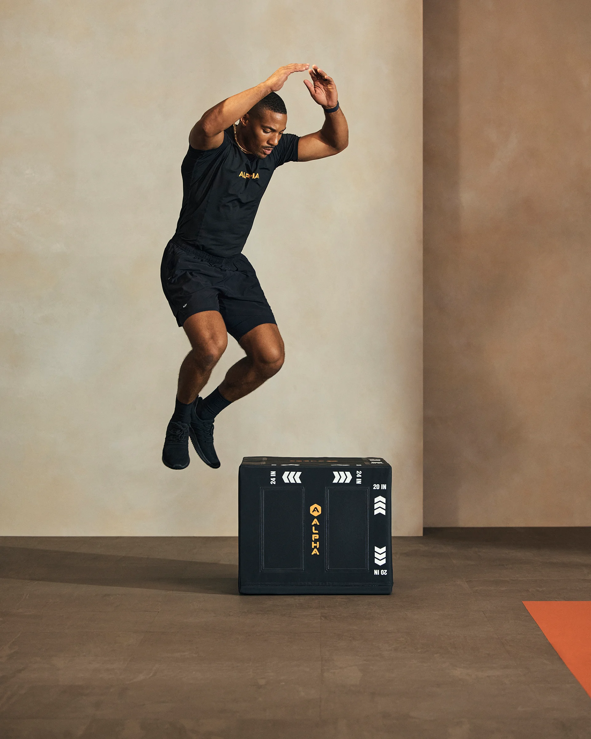 A Life Time member jumping off a plyo box in an Alpha class.