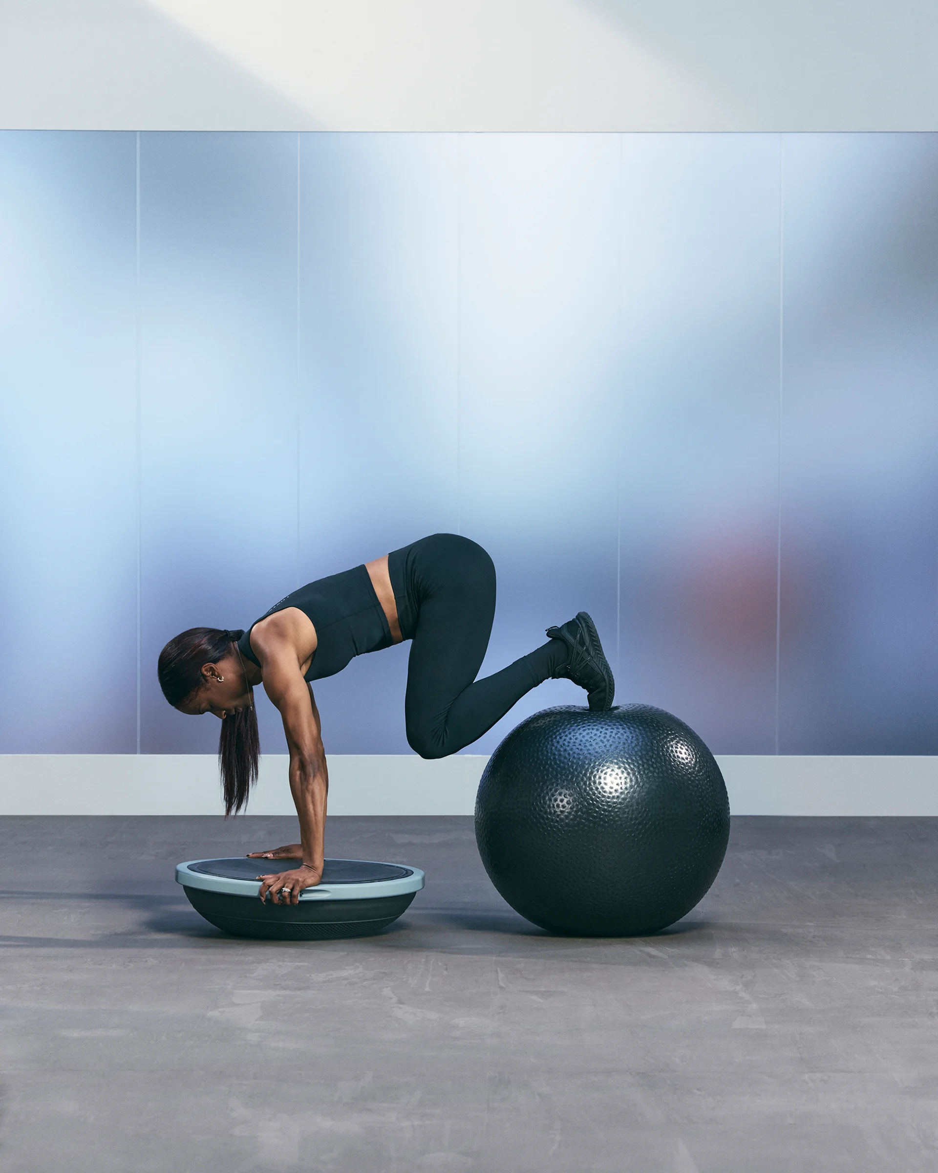 A Life Time member planking with a BOSU and stability ball.