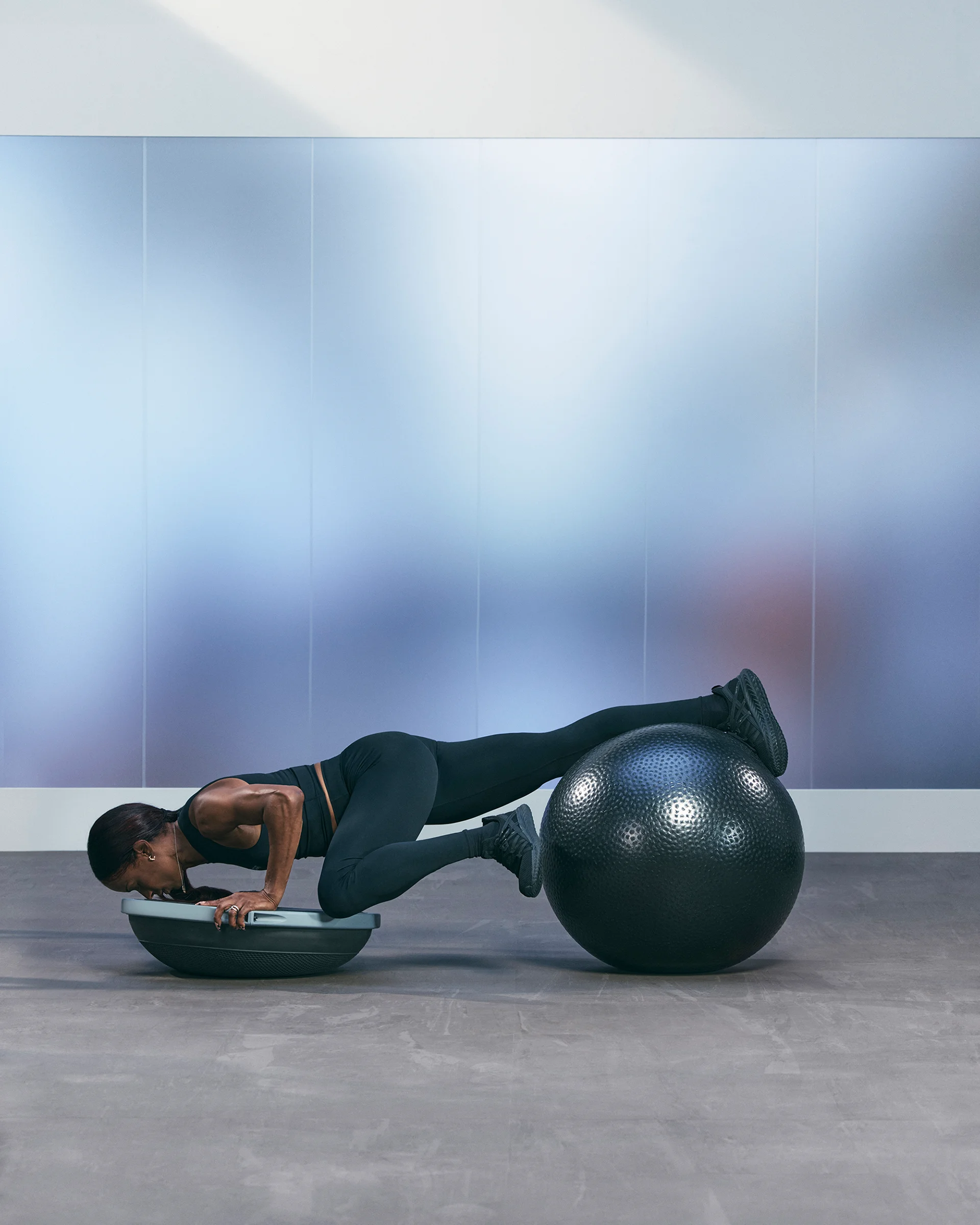 A Life Time member doing a pushup with a BOSU and stability ball.
