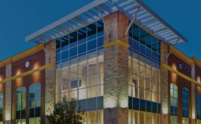 The exterior of a Life time building all lit up at dusk