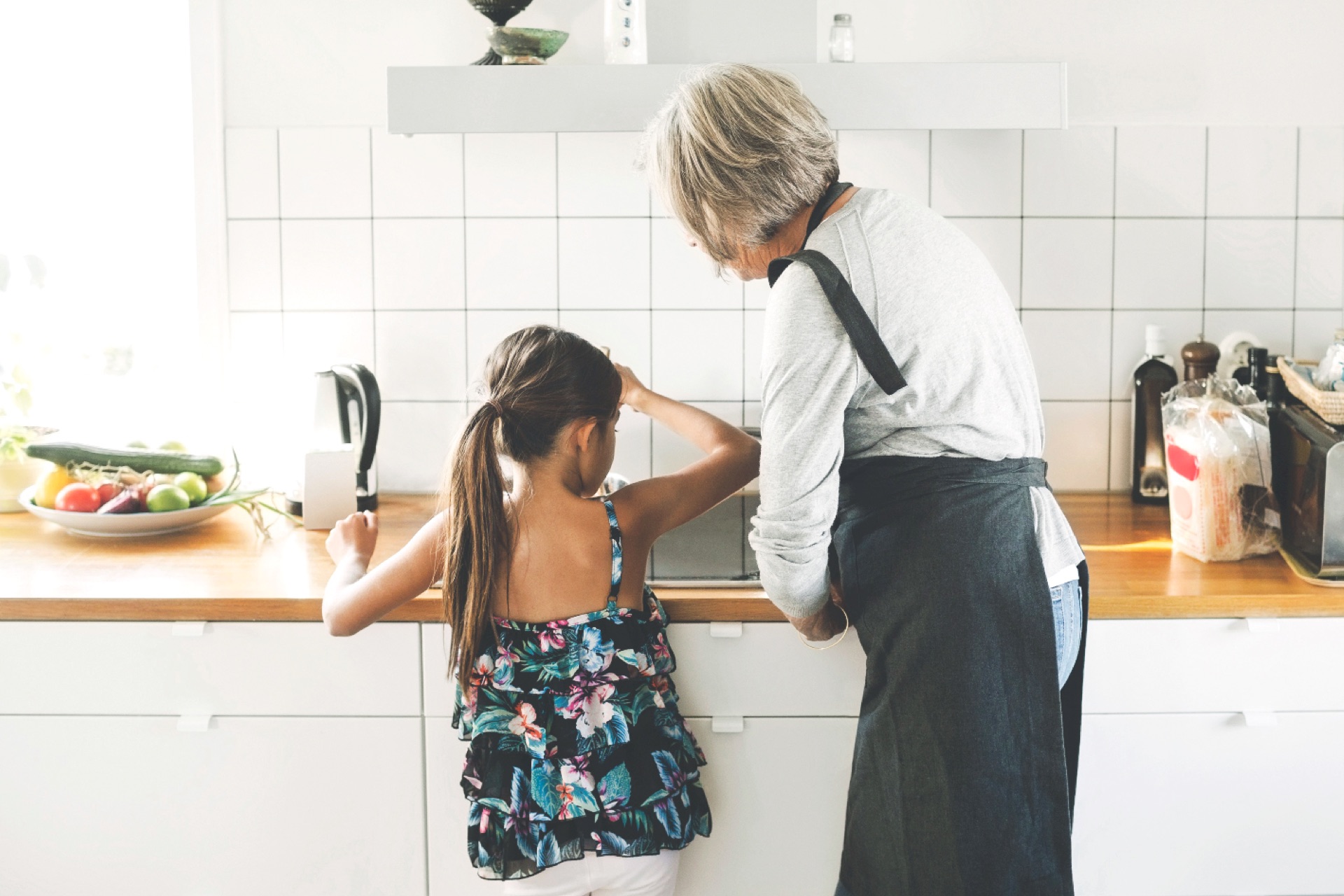 Woman and female child cooking together in a kitchen