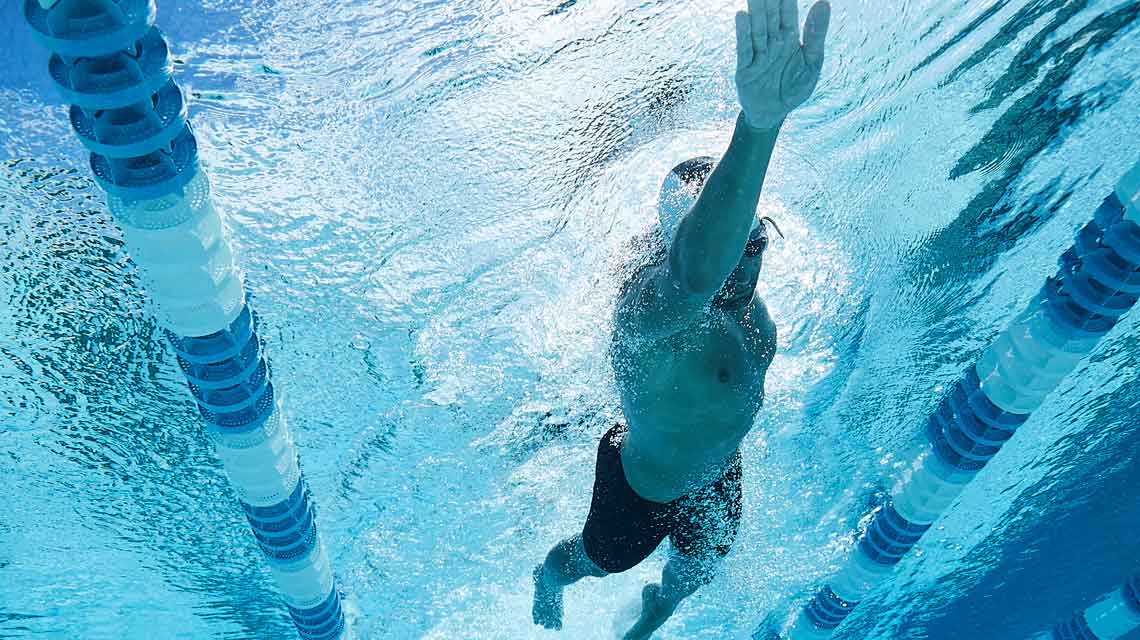 An underwater view of a male swimmer swimming laps