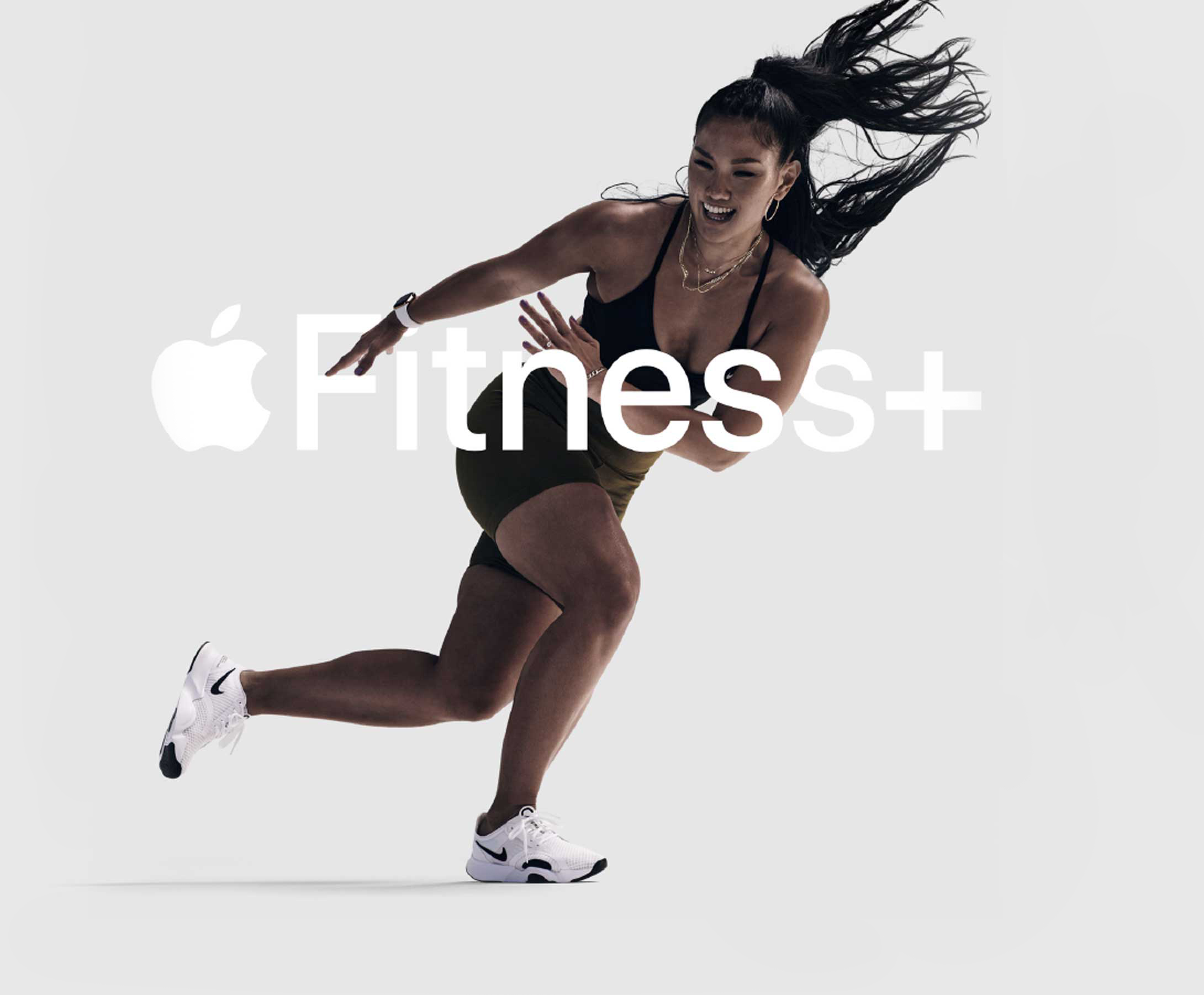 A woman frozen in motion, performing a side lunge, with the apple fitness plus logo overlaid.
