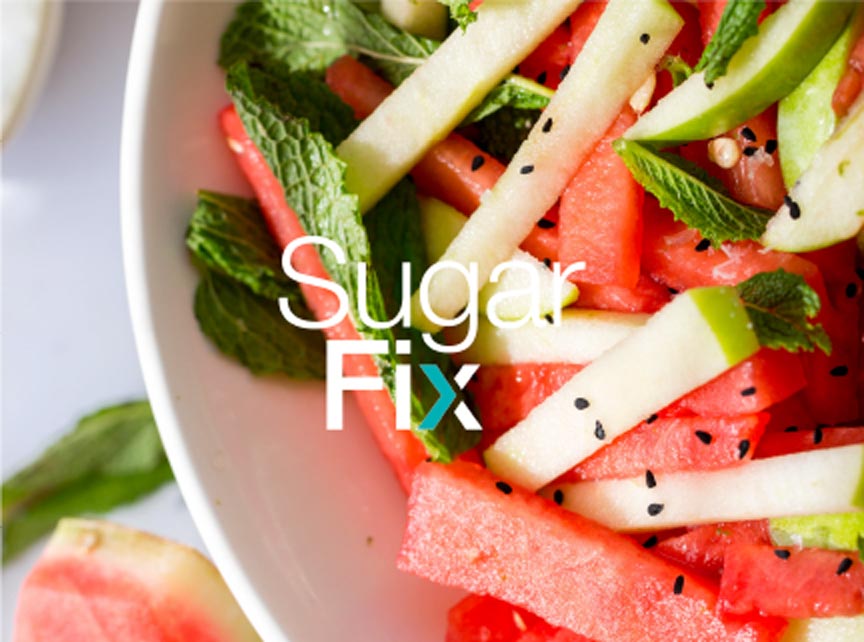 close up of a bowl of cut watermelon and apples, with the sugar fix logo overlaid on the image