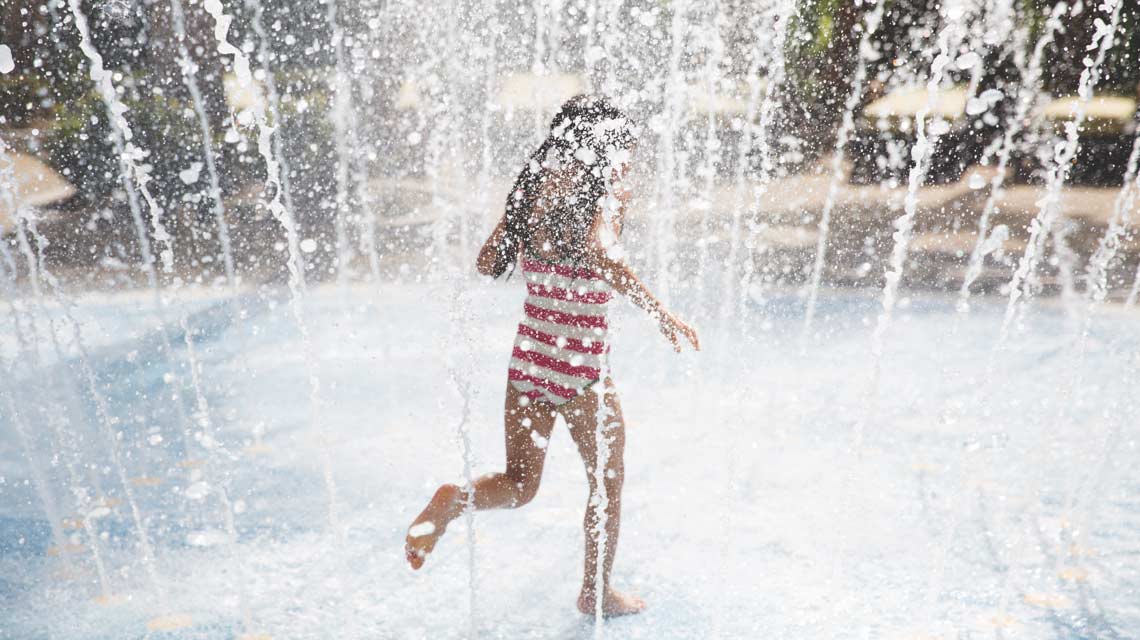 A girl running through water at Life Time