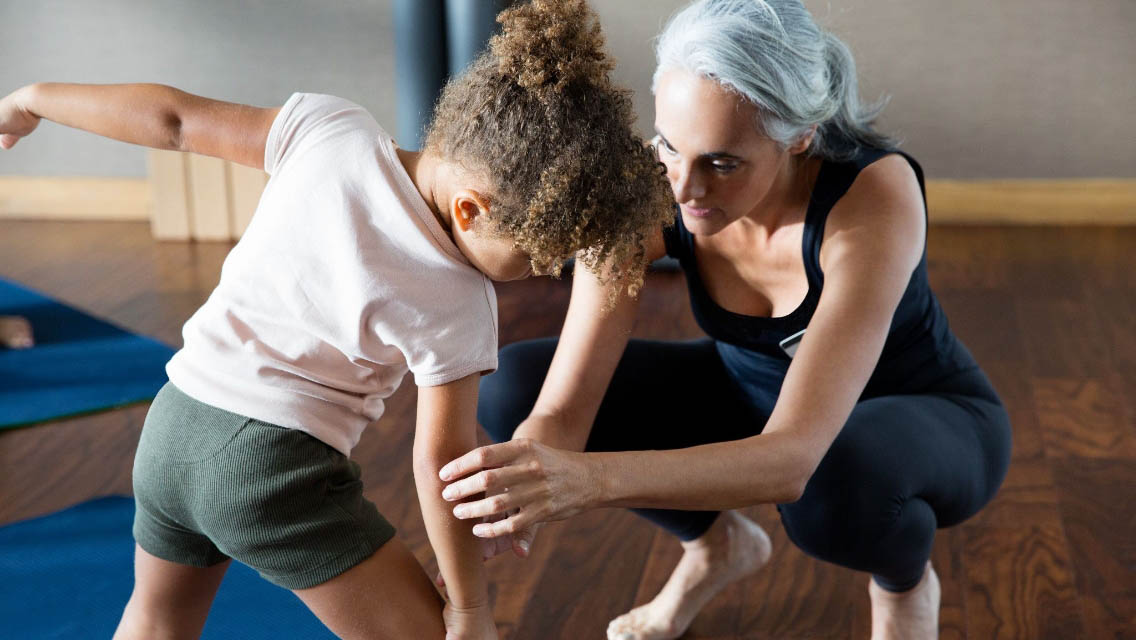 An instructor teaching a child yoga