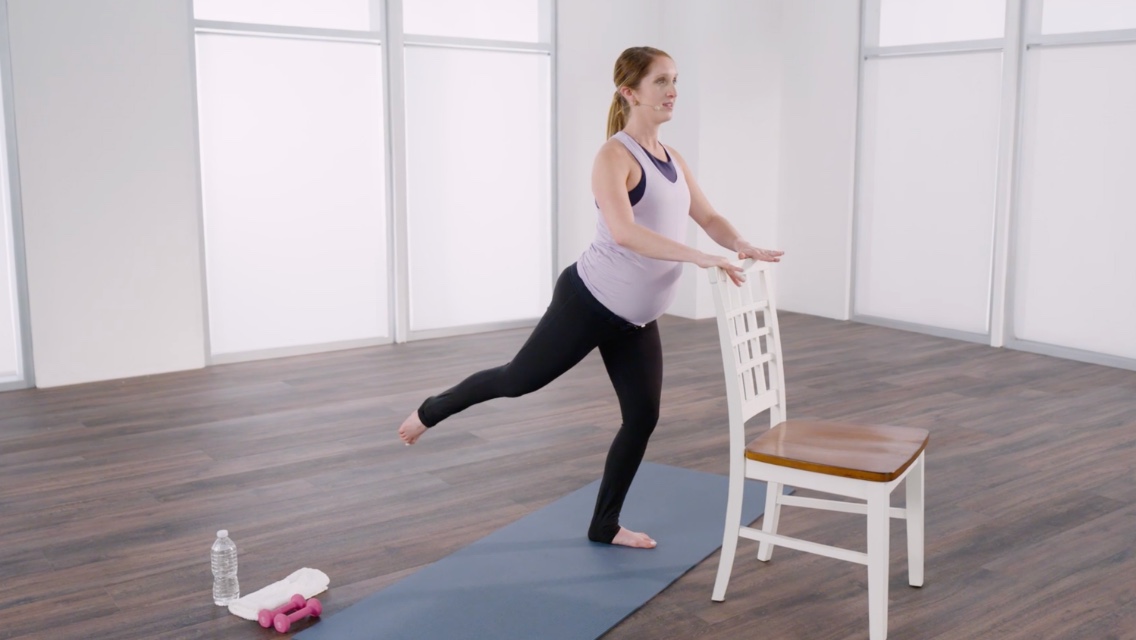 Woman taking a Full Body Barre 45 class at home with Life Time Classes On Demand