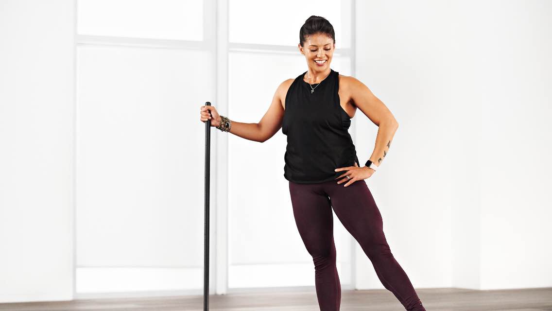 A woman doing an at home Life Barre workout with Life Time Classes on demand