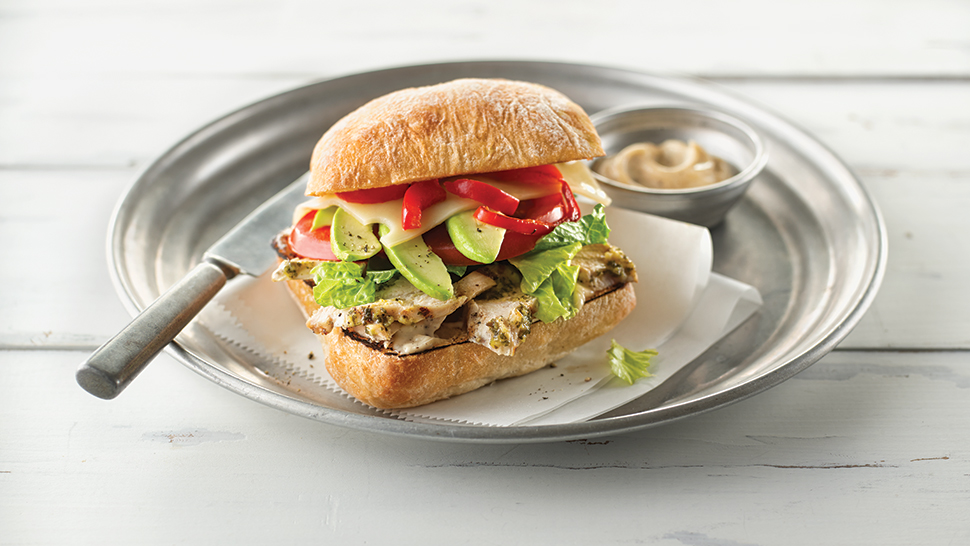 A sliced chicken sandwich on a white plate
