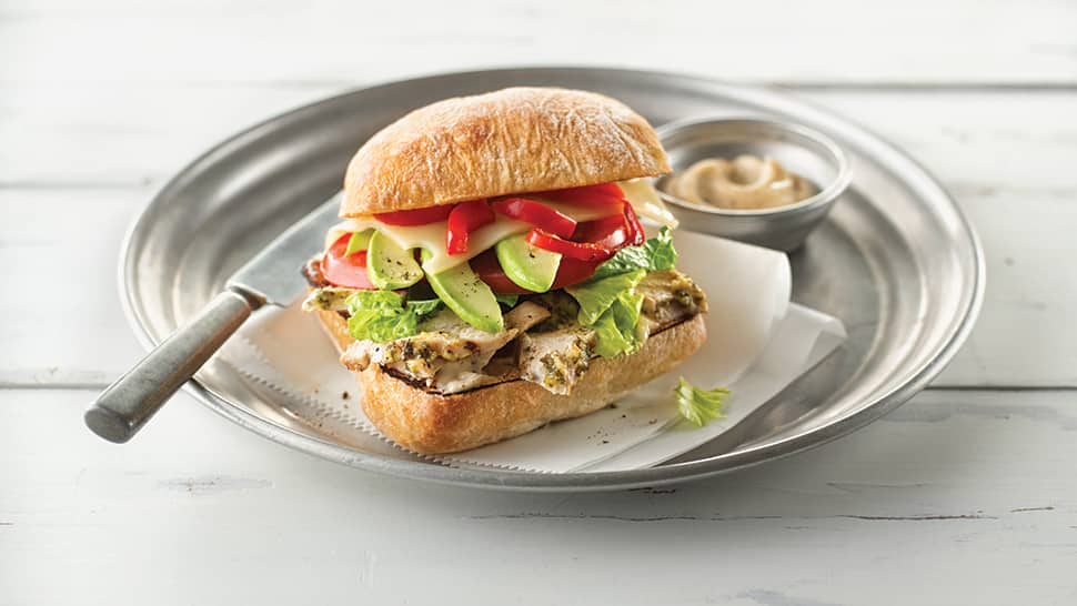 A sliced chicken sandwich on a white plate
