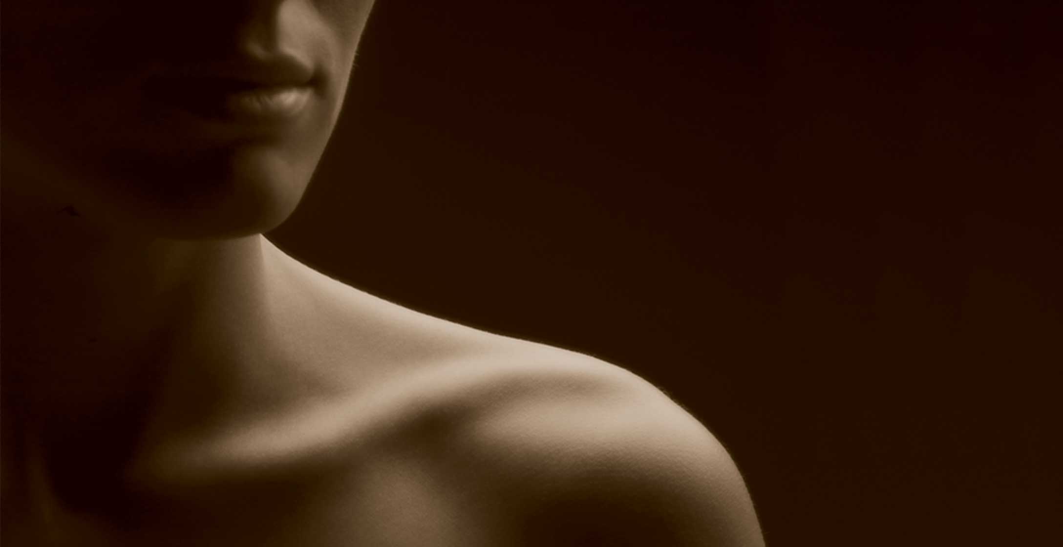 The chin and bare left shoulder of a woman