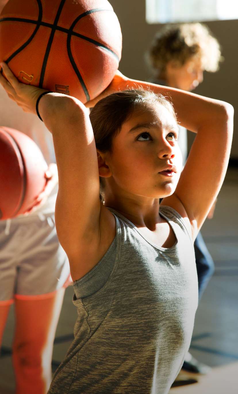 a girl concentrates before shooting a basketball