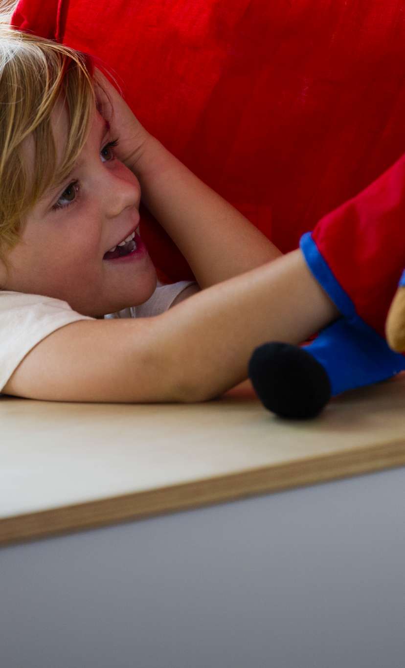 a child plays with a puppet