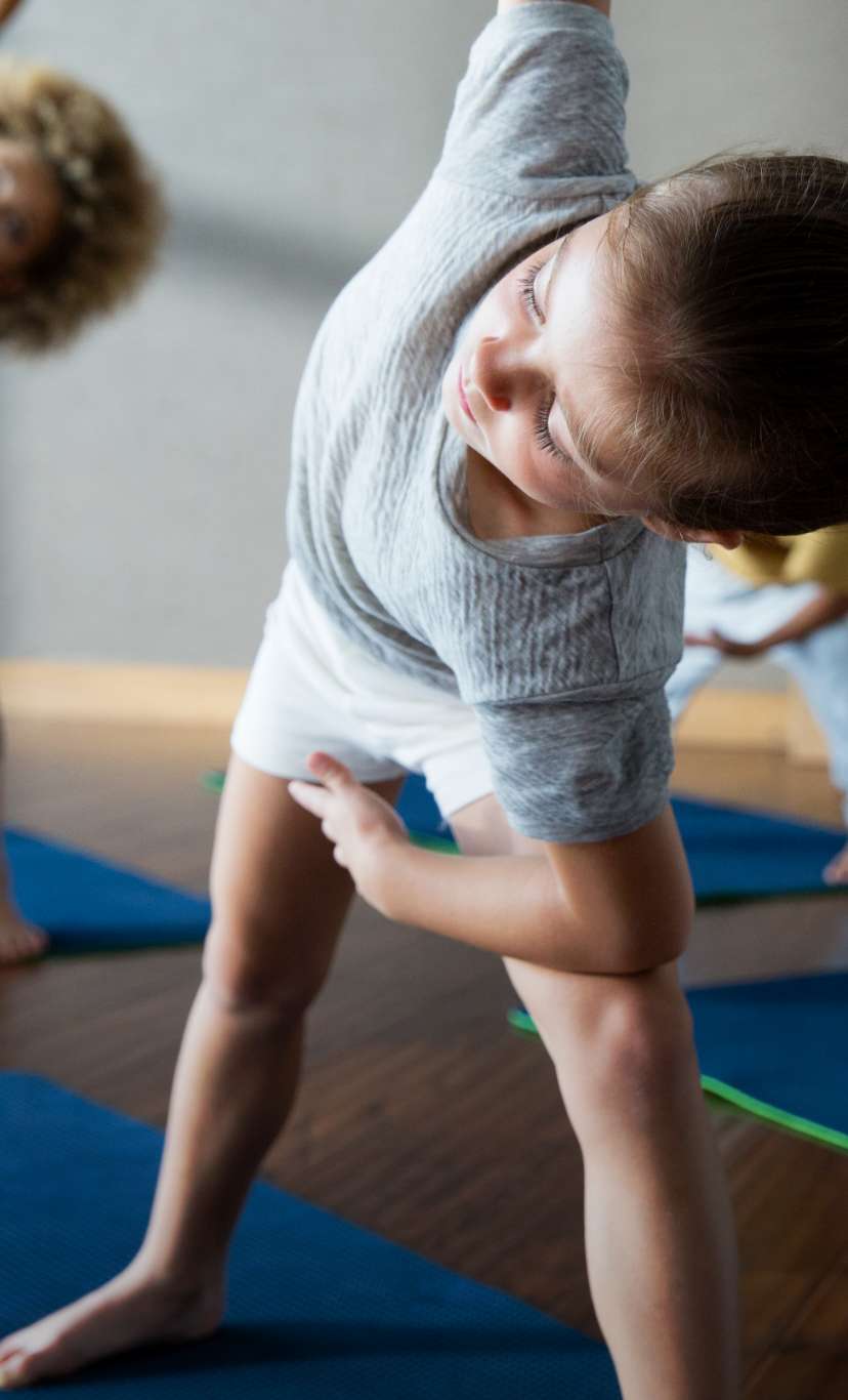 a group of children participate in a yoga class