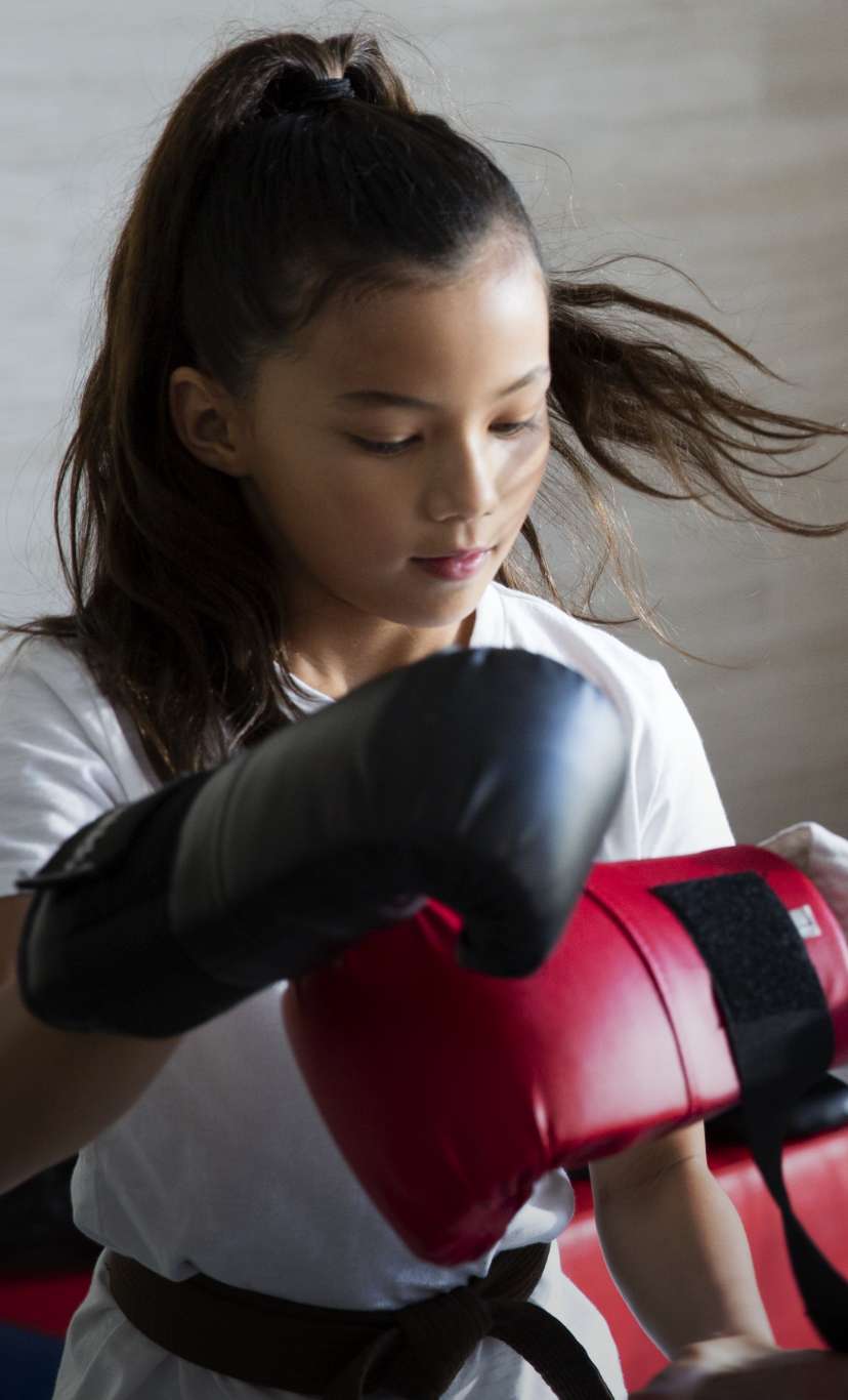 a boy and a girl participate in a boxing class