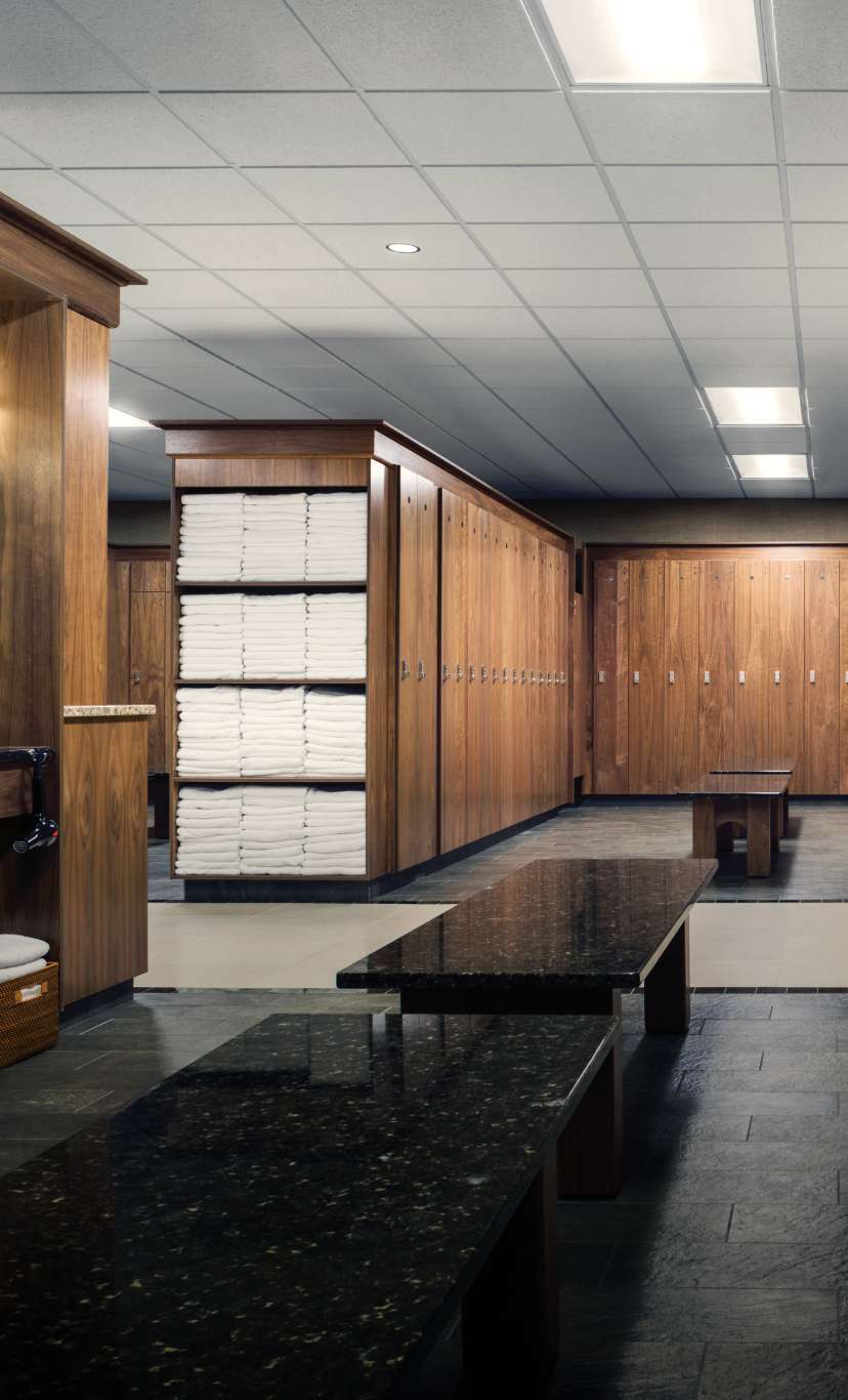 a dark wood and marble locker room with fresh towels