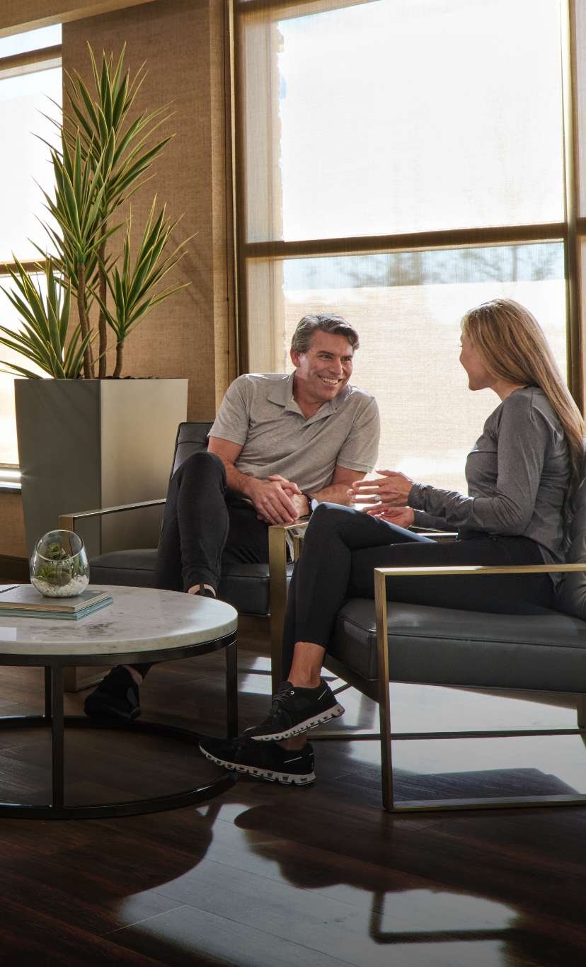 a man and a woman converse in a cozy lounge area