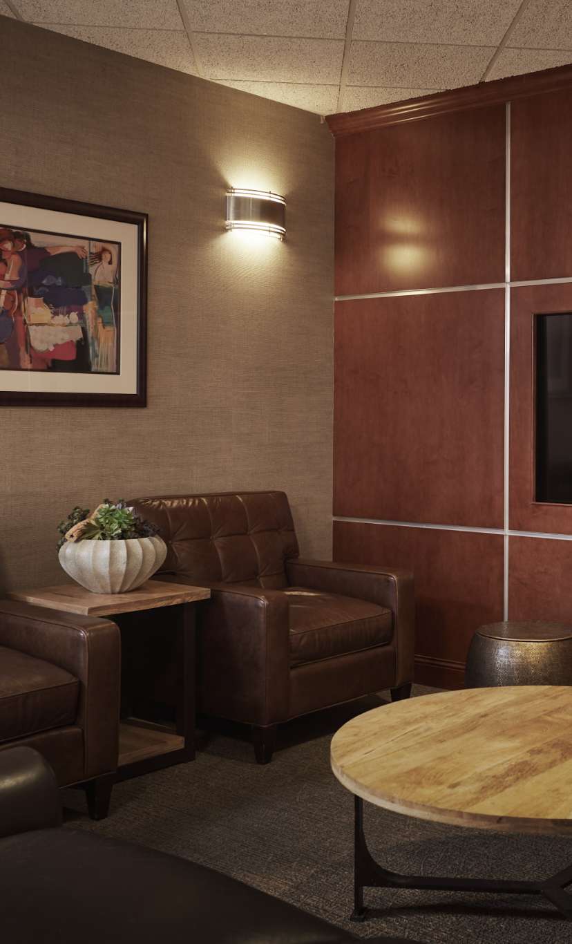 A wood wall with TV, and cozy couches in a locker room lounge area