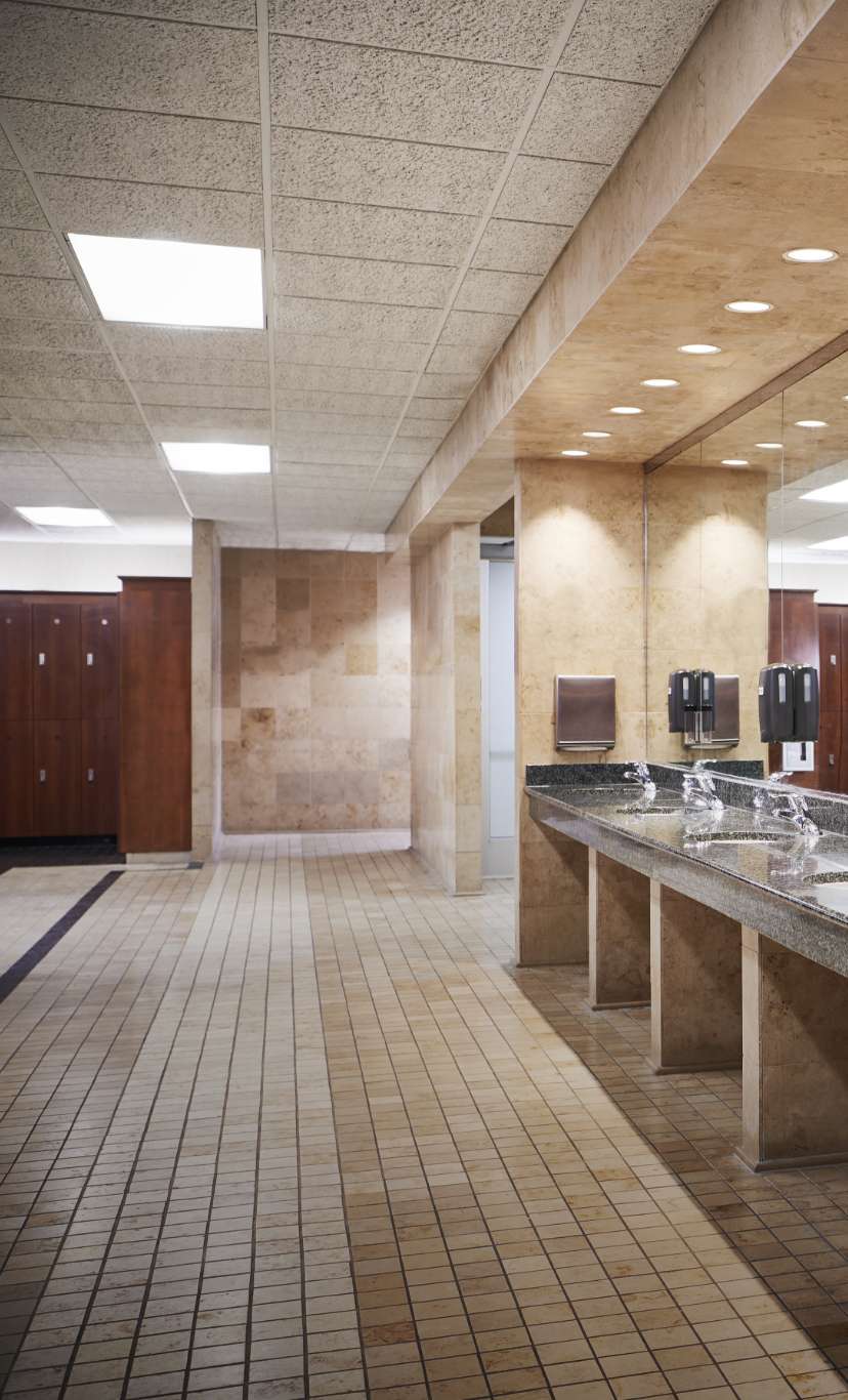 an expansive luxury locker room with marble sinks and vanity area