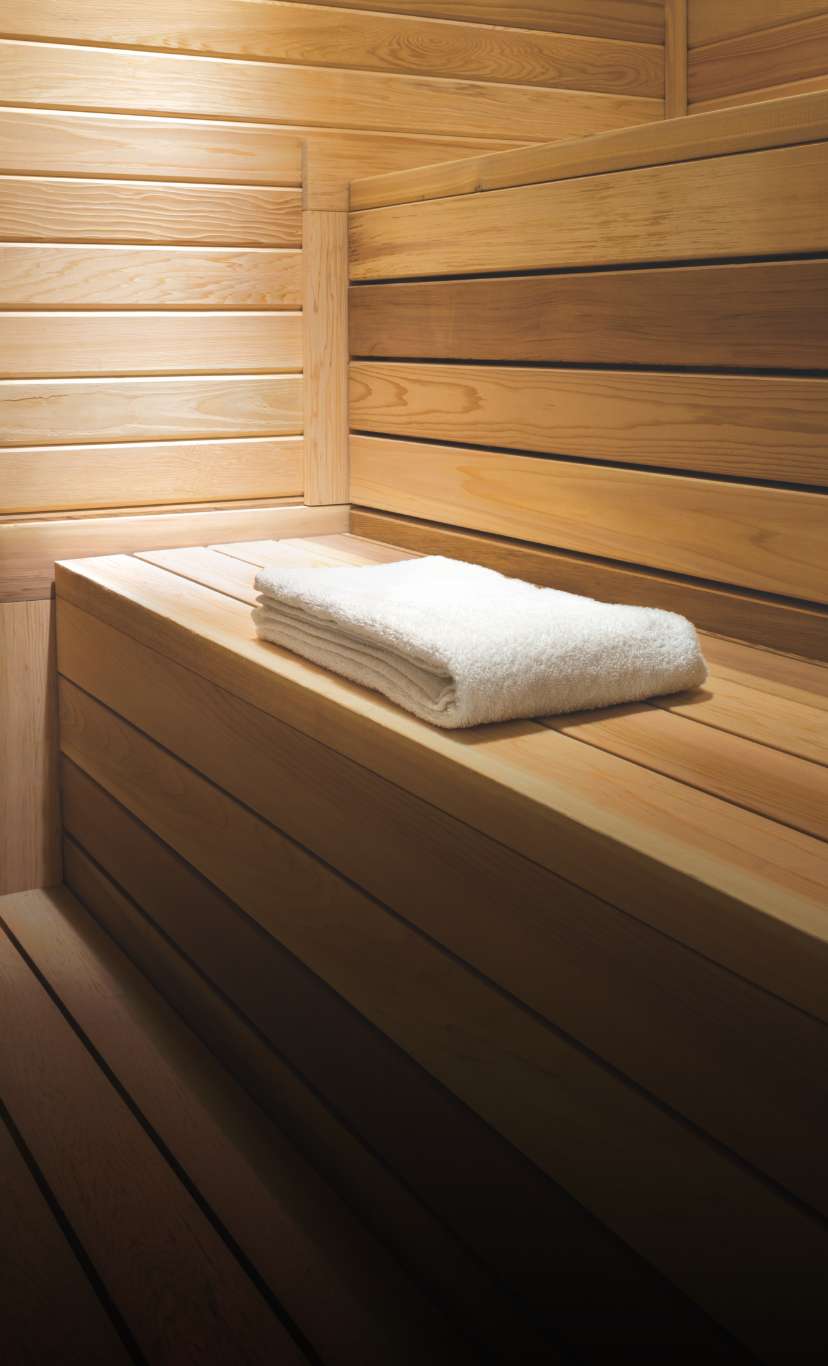 a white towel sits folded inside a luxurious cedar wood sauna