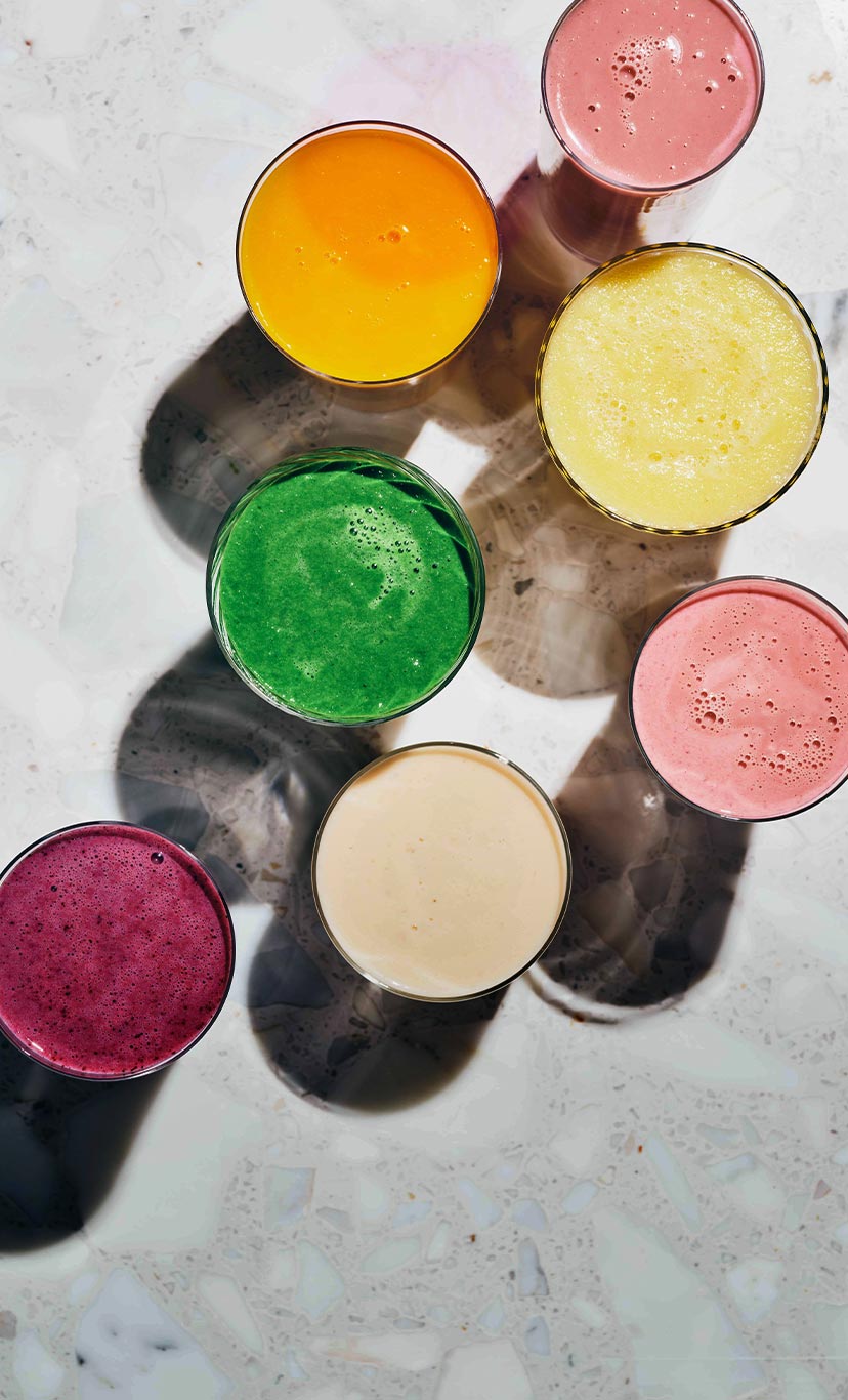 an overhead view of many smoothies in many colors