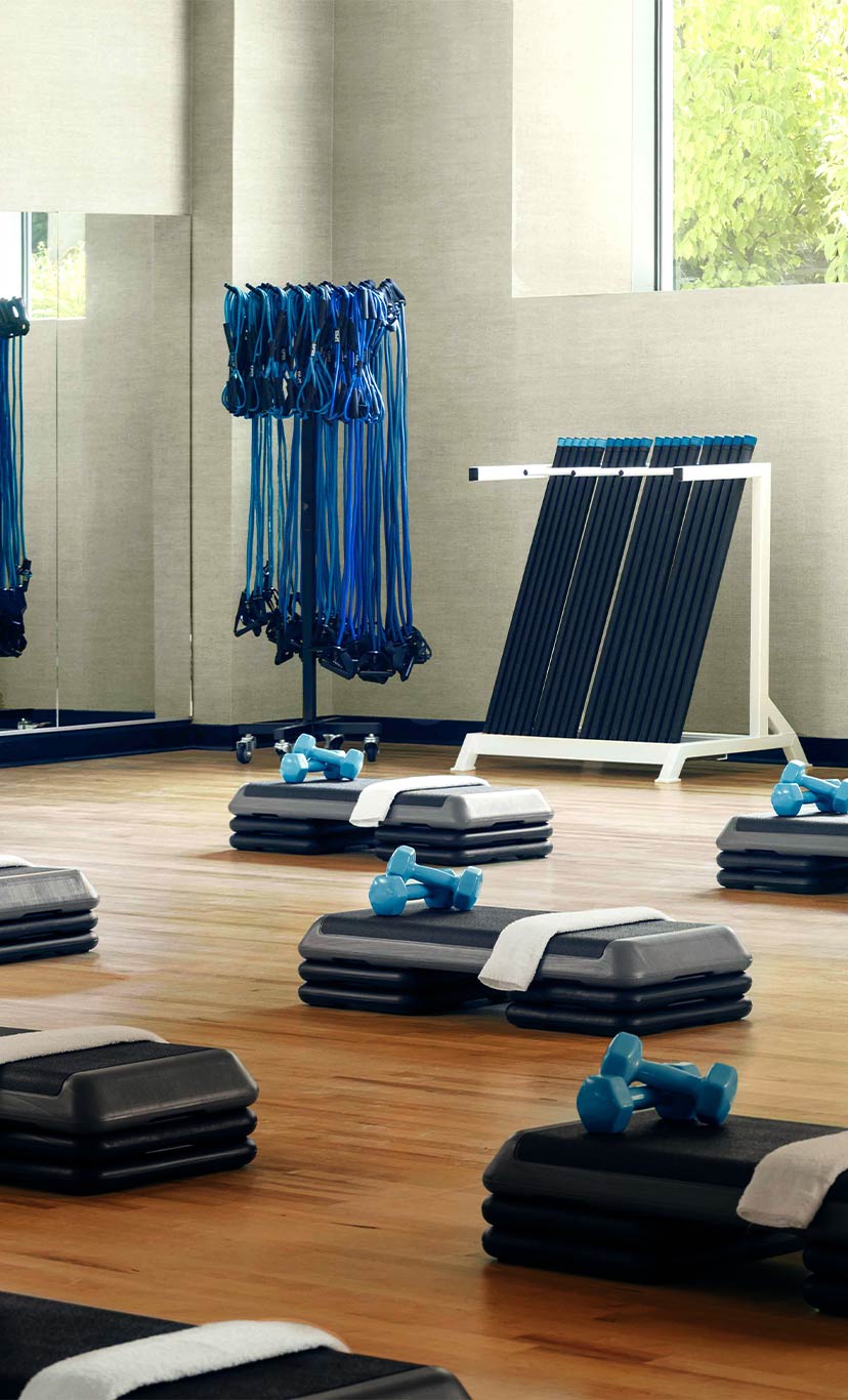 studio equiped with aerobic steps, dumbells, towels, and stretch cords