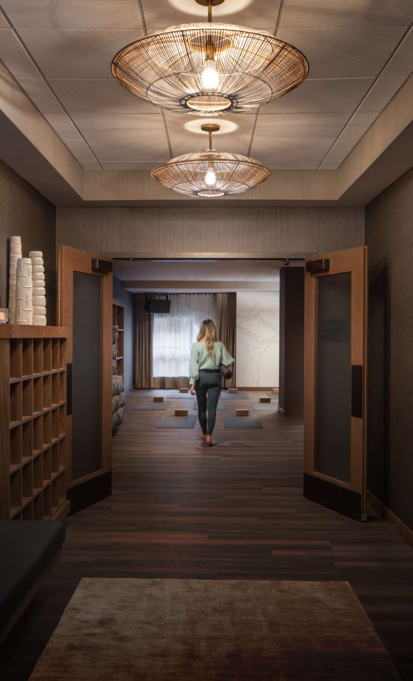 a woman walks through the yoga studio area halllways