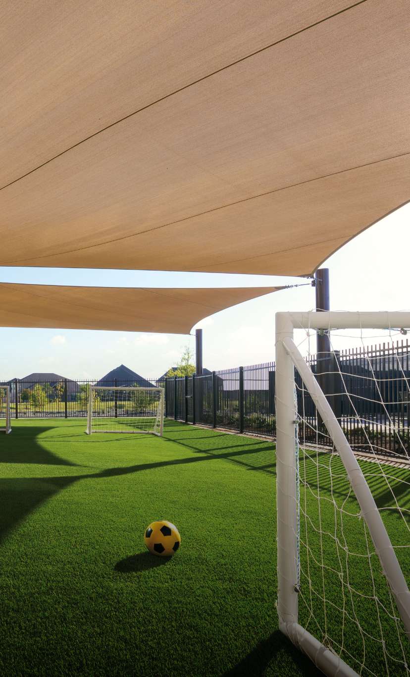 an outdoor soccer field with awning and goal nets