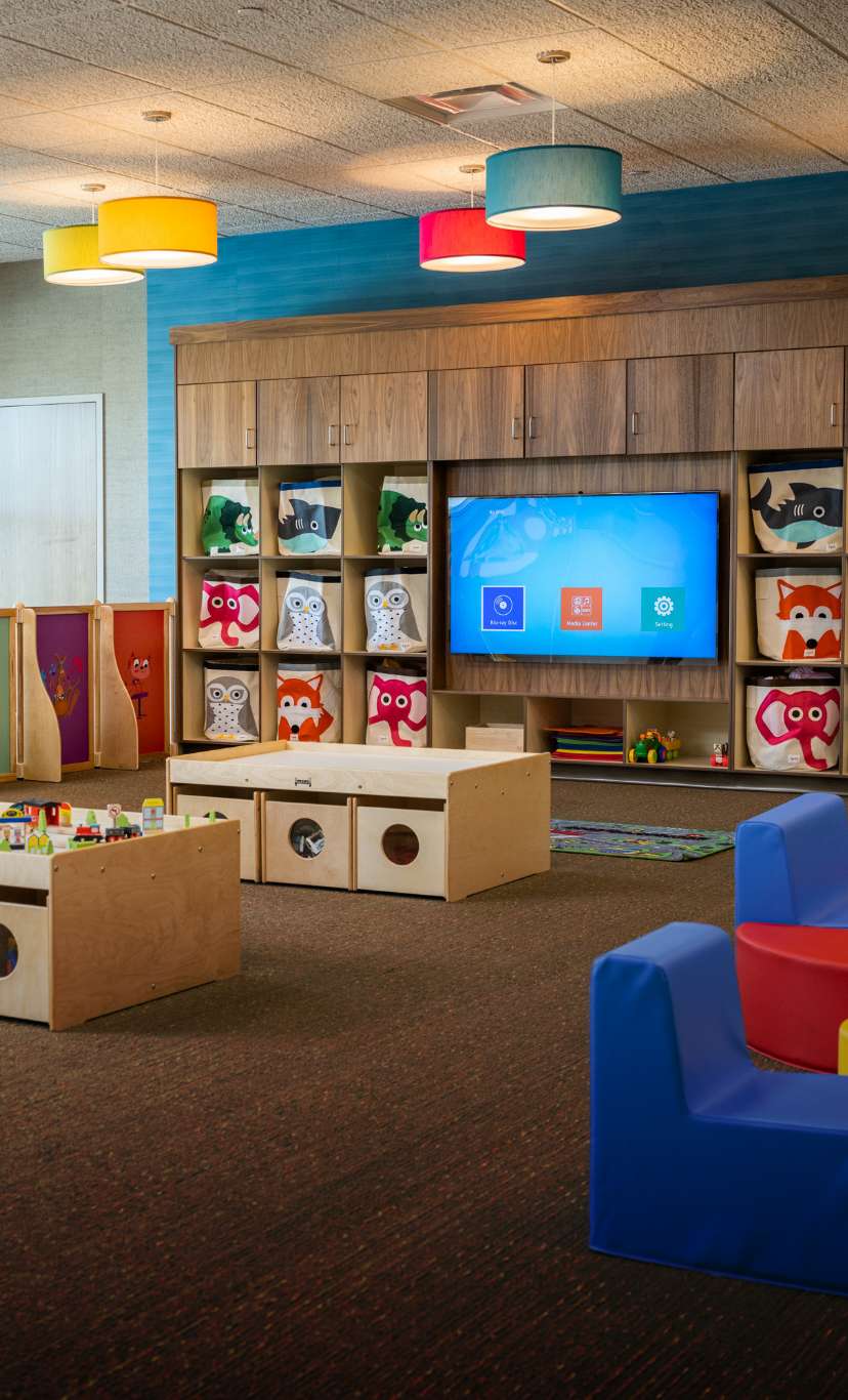 A kids play area with chairs and TV