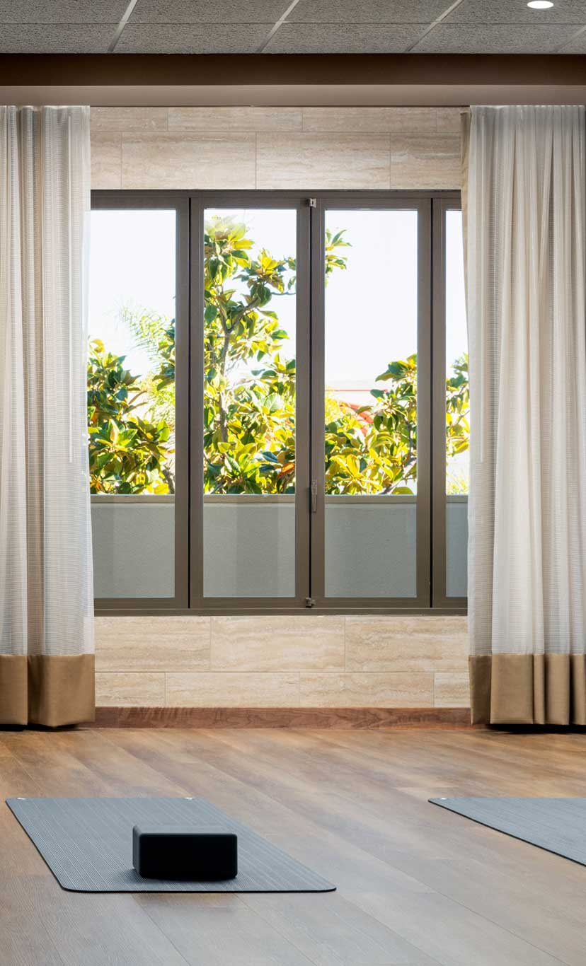 yoga mats and yoga bricks laid out in a warmly lit yoga studio