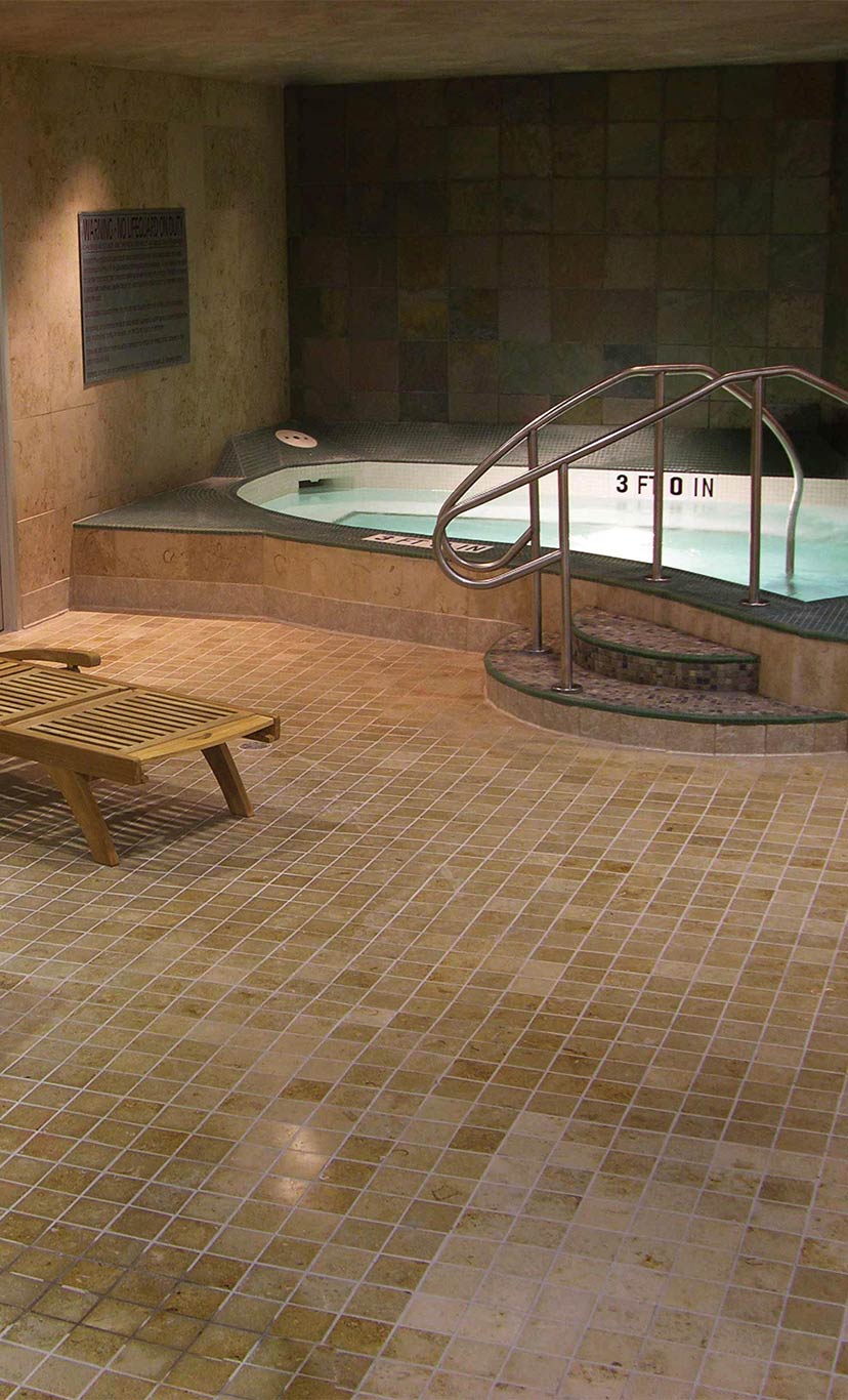a luxurious whirlpool area with bubbling whirpool and lounge chair on deck