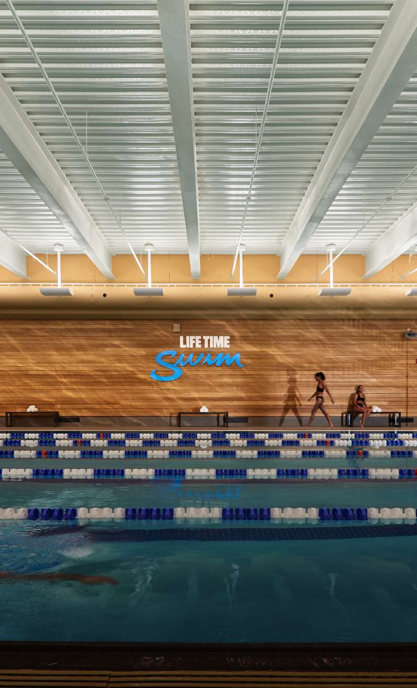 a man swim laps at an indoor lap pool