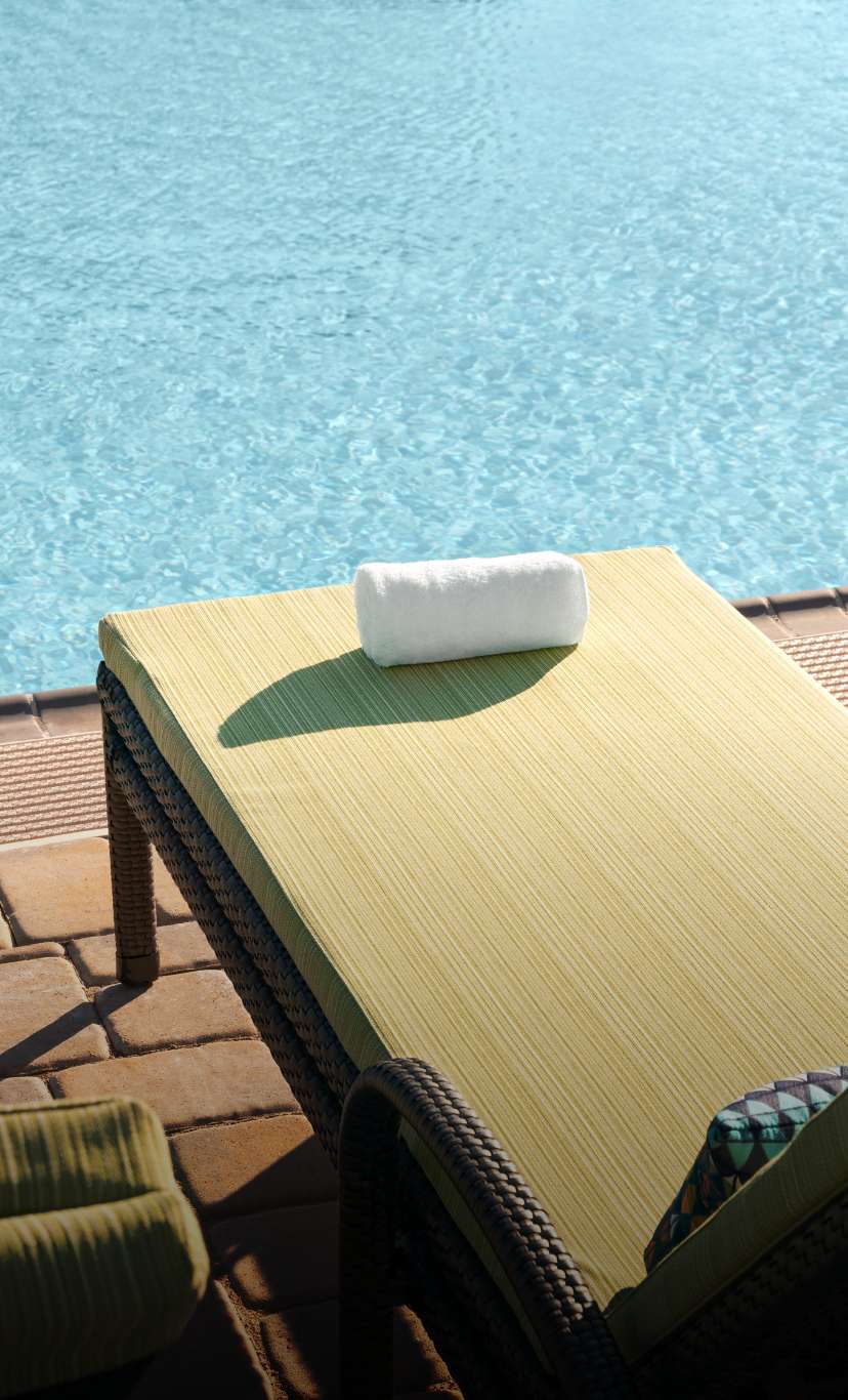 A lounge chair by an outdoor pool