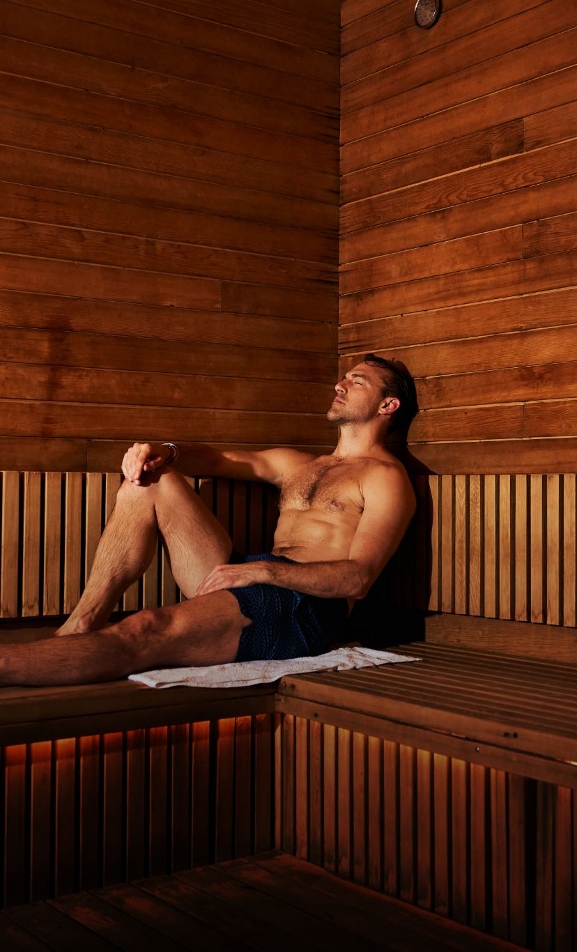 a man relaxes in a dimly lit cedarwood sauna