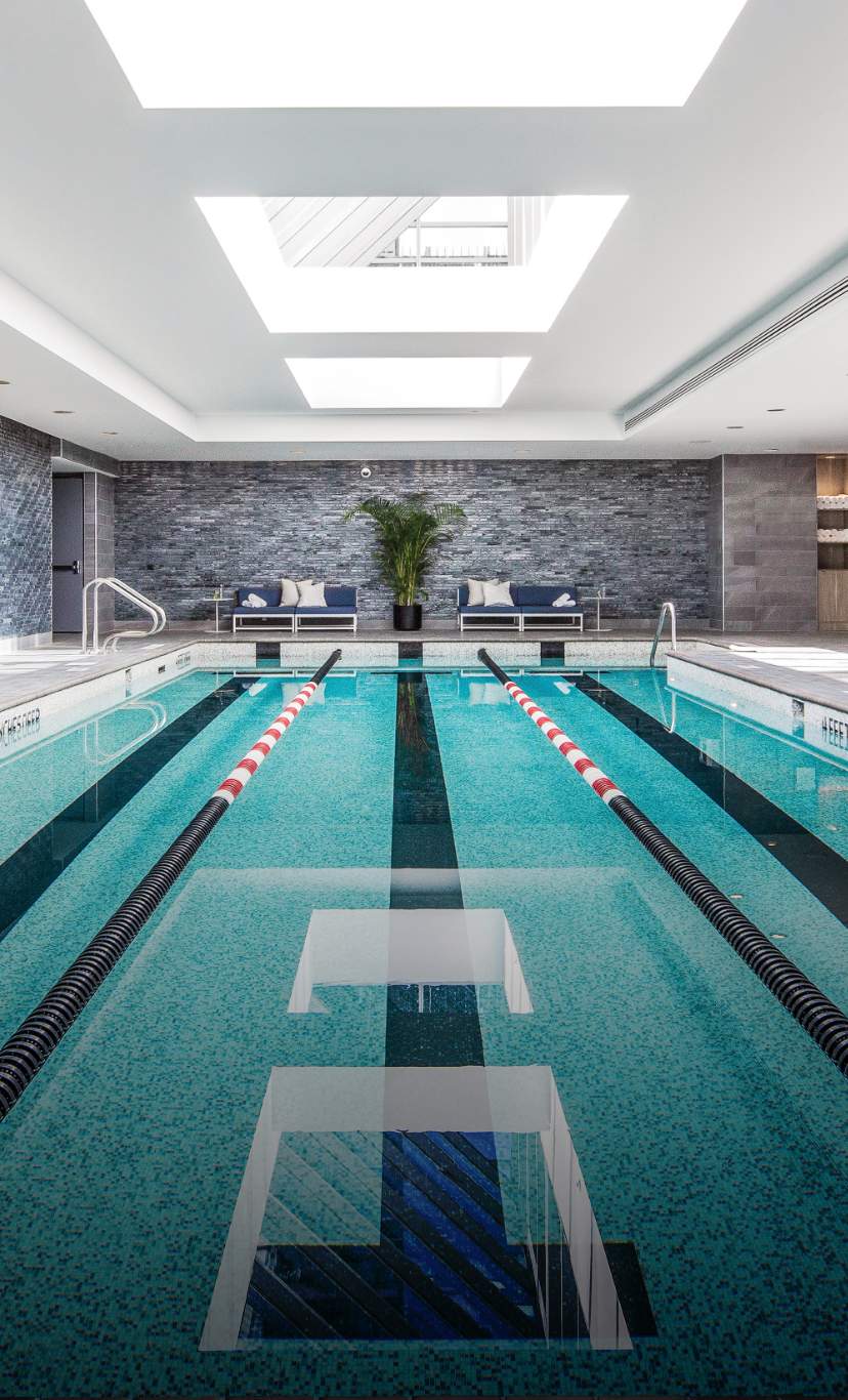 A 3 lane indoor lap pool with lane lines and sky lights