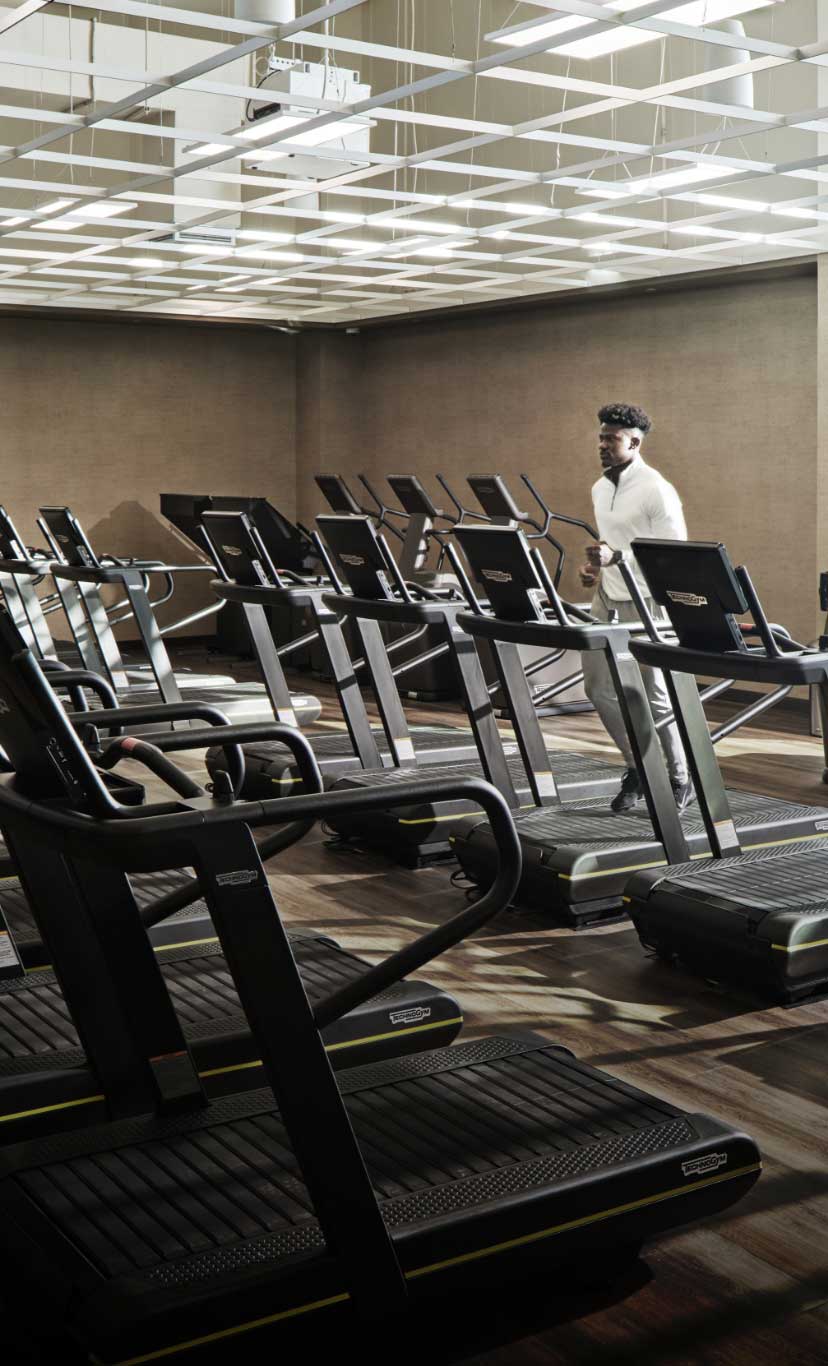 a man runs on a treadmill in a cardio machine area