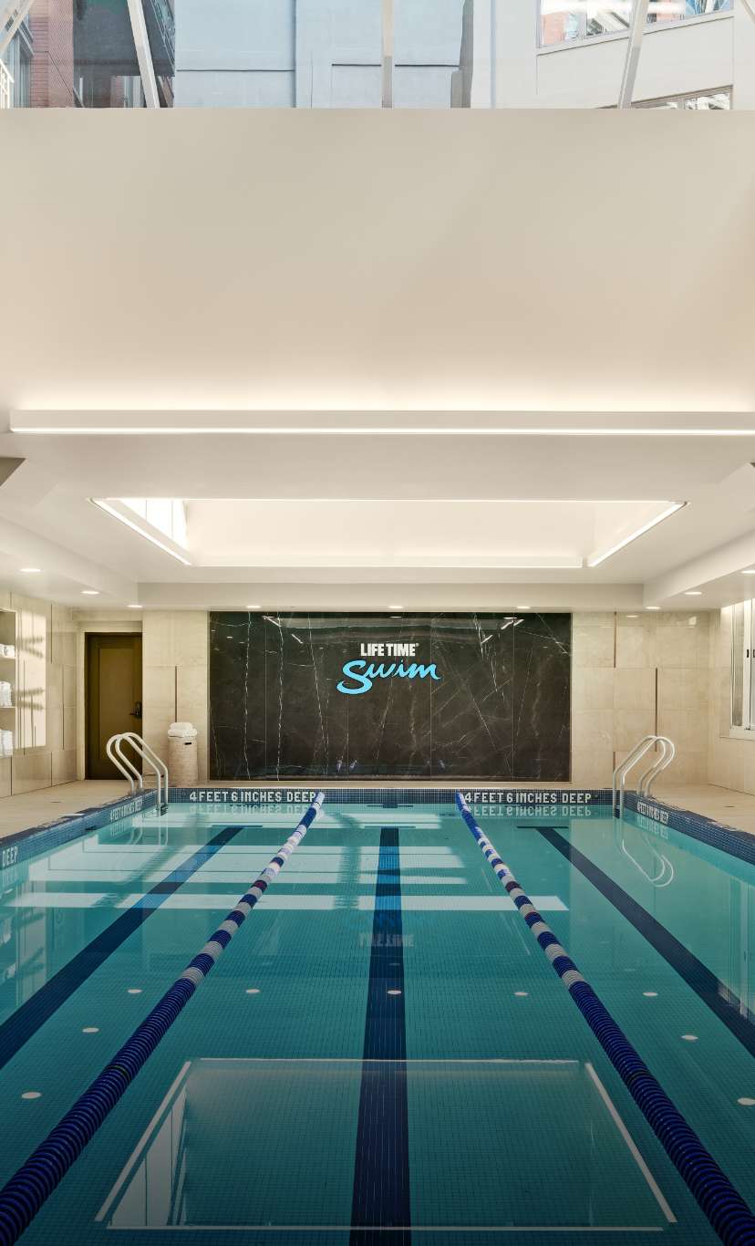 A 3 lane indoor lap pool with lane lines and sky lights