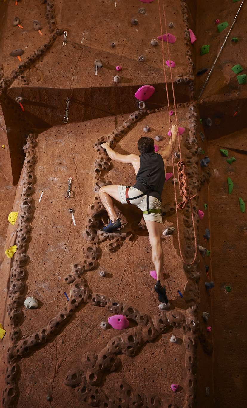 a climber nears the top of a indoor rock wall