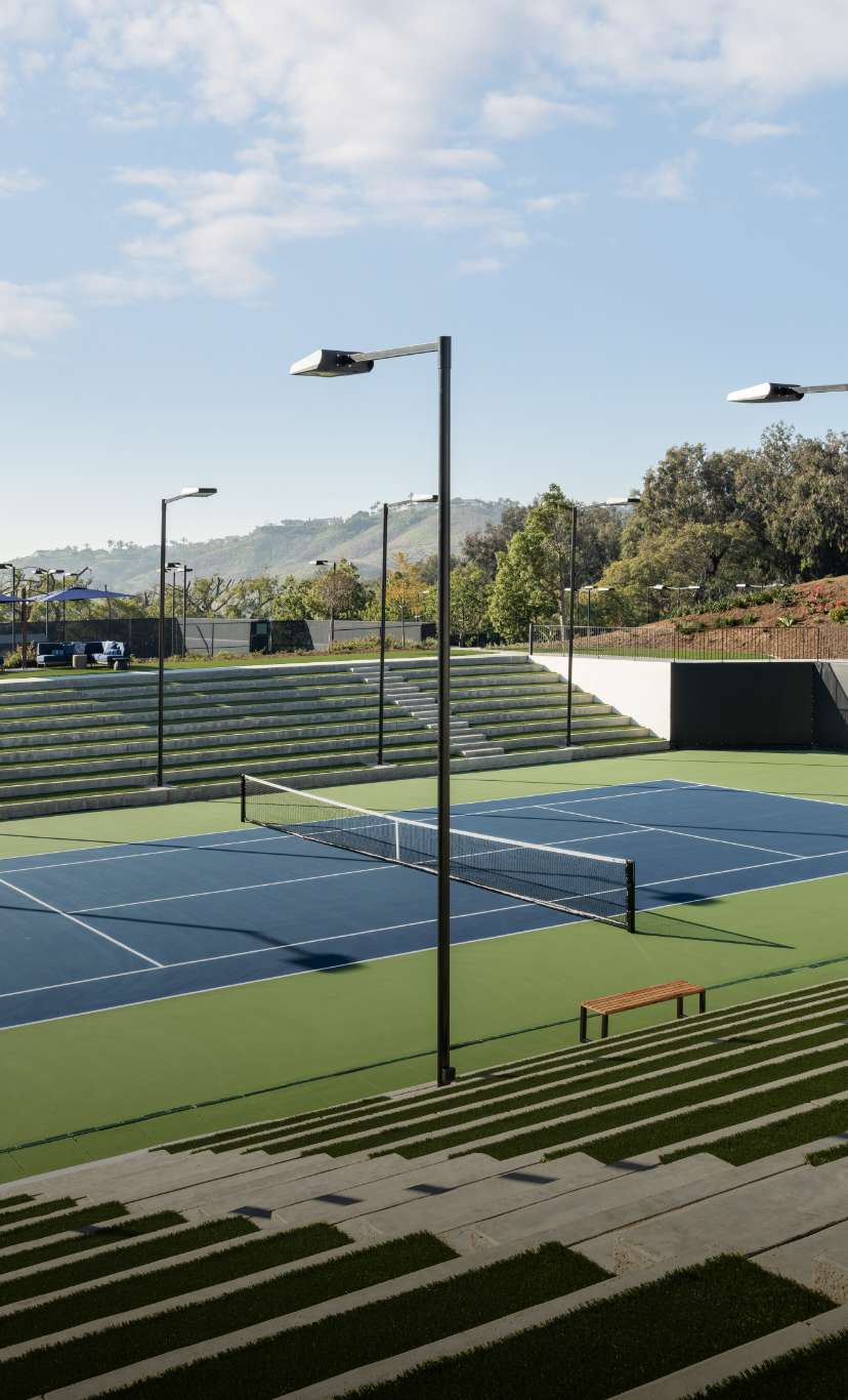 An outdoor tennis court stadium with spectator stands