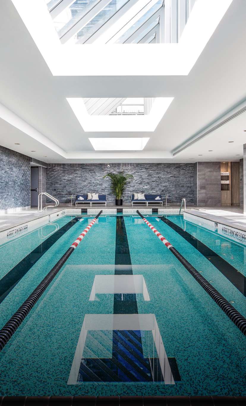 An indoor lap pool with lane lines and sky lights