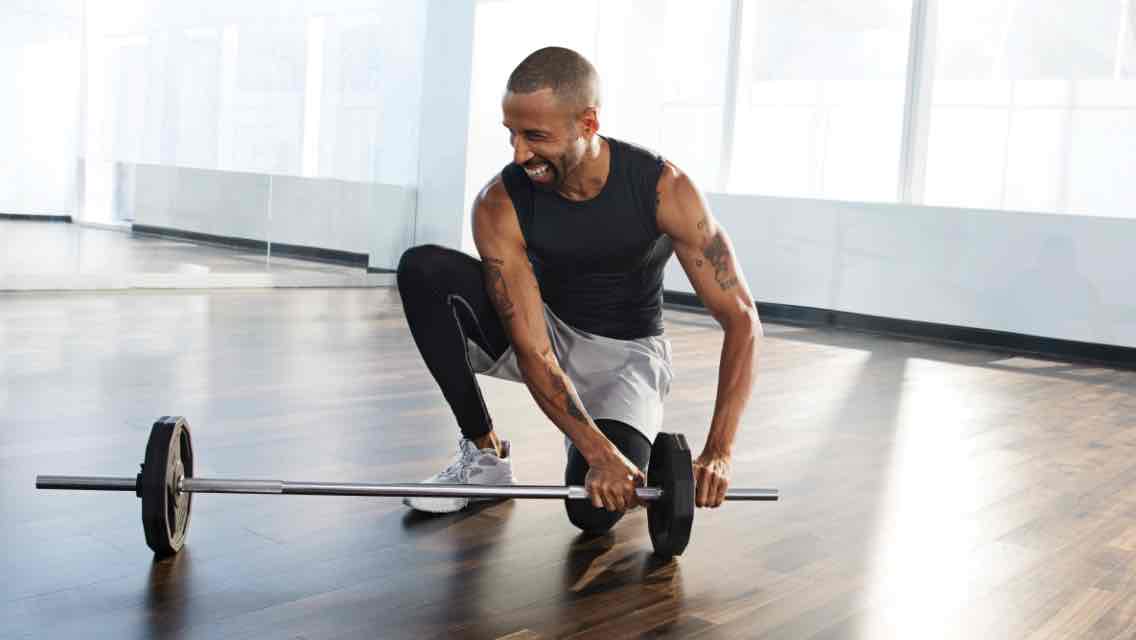 a man puts a weight on a barbell