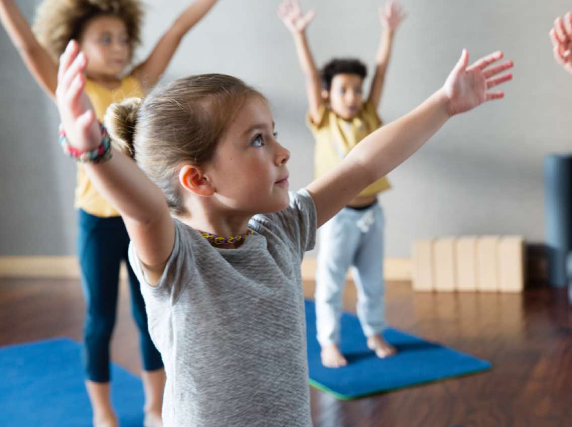 Kids standing on yoga mats in a Kids Academy class at Life Time
