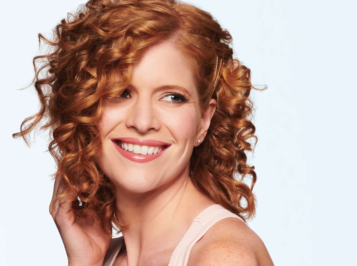 Woman with medium-length red, curly hair