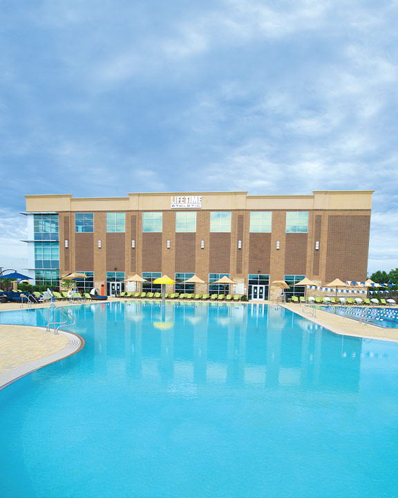 A large, blue, outdoor leisure pool at Life Time