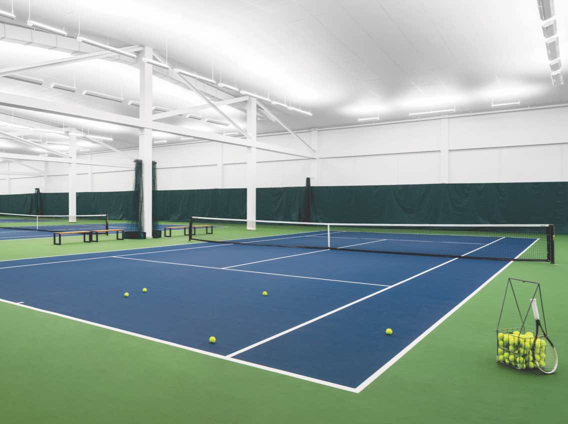 Expansive view of an indoor tennis facility at Life Time