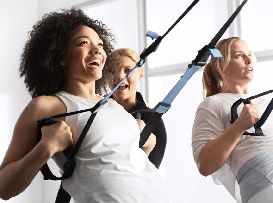 Smiling woman working out with a personal trainer at Life Time