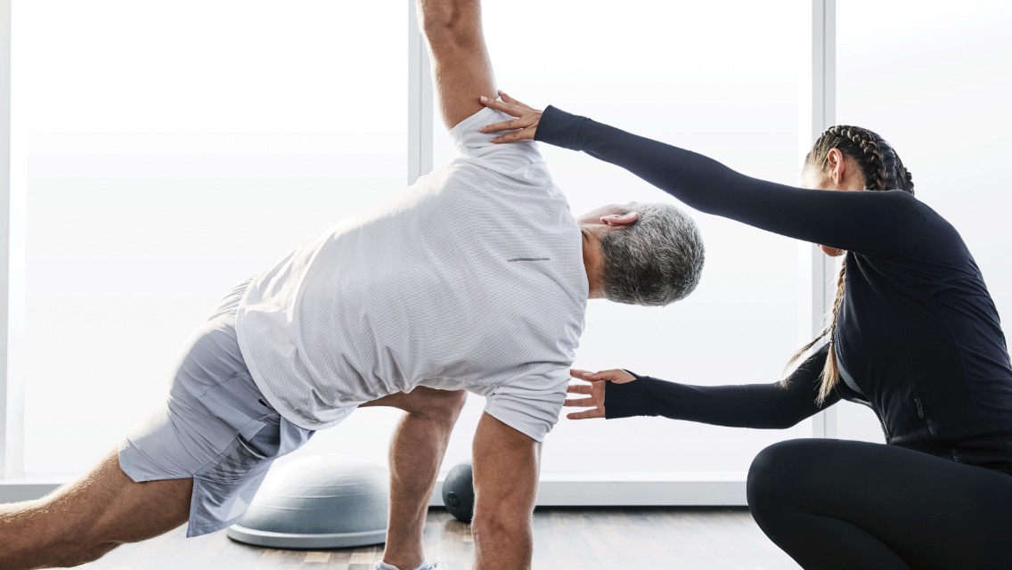 Personal trainer helping a female member during a personal training session.